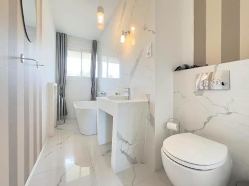 une salle de bain blanche avec des toilettes et un lavabo dans l'établissement Le Montfleury by Winsome Destination, à Cannes