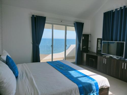 a bedroom with a bed and a view of the ocean at Muine Pacific Resort in Mui Ne