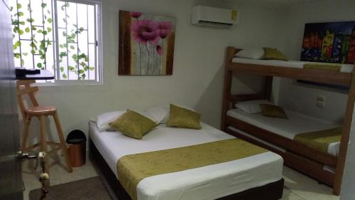 a bedroom with two bunk beds and a window at Casa Hotel Manga Mar in Cartagena de Indias