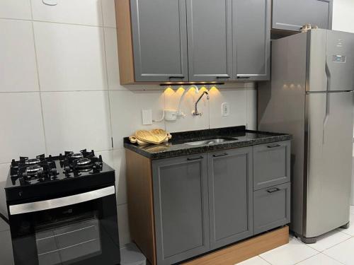 a kitchen with a stove and a refrigerator at Sinta-se em casa! in Sorocaba