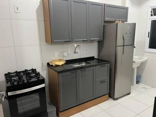 a kitchen with a stainless steel refrigerator and a sink at Sinta-se em casa! in Sorocaba