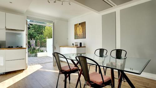 une salle à manger avec une table et des chaises en verre dans l'établissement Maison Cozy - Au calme avec terrasse, à Cholet