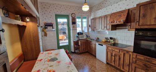 une cuisine avec des armoires en bois et une table à l'intérieur dans l'établissement Maison familiale, à Ax-les-Thermes