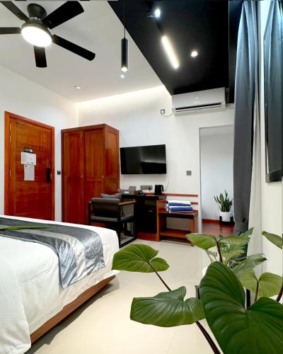 a bedroom with a bed and a desk and a tv at Baa Sand Maldives in Kudarikilu