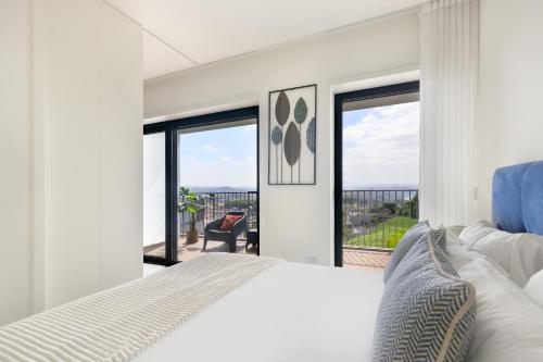 a bedroom with a white bed and a large window at Dragão - Indigo Antas Park in Porto