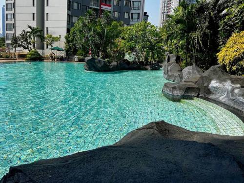 a swimming pool with blue water in a city at Luxury & Stylish Apt Rasuna 2BR with Pool n Gym by 2ndHome in Jakarta