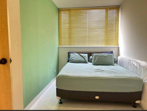 a bed with two pillows in a room with a window at Luxury & Stylish Apt Rasuna 2BR with Pool n Gym by 2ndHome in Jakarta