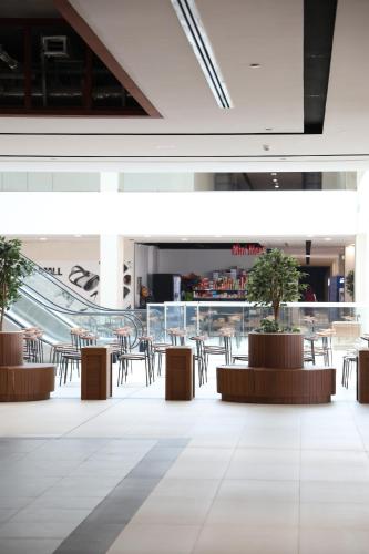 a lobby with tables and chairs in a building at The Myriad Muscat - Female Only ذا ميرياد مسقط - للنساء فقط in Seeb