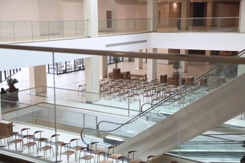 an empty hall with chairs and stairs in a building at The Myriad Muscat - Female Only ذا ميرياد مسقط - للنساء فقط in Seeb
