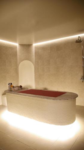 a white kitchen with a sink and a red rug at The Myriad Muscat - Female Only ذا ميرياد مسقط - للنساء فقط in Seeb