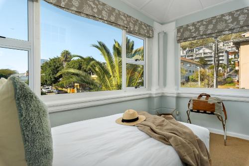 a bedroom with a bed with a hat on it at Neighbourgood Hill in Cape Town