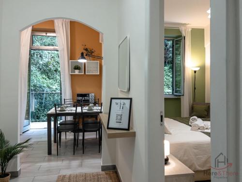 a dining room with a table and a bedroom at Venice Suite - Cruises 500m - AC - Smart TV in Genova