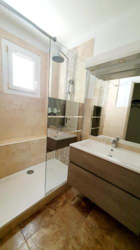 une salle de bain avec une baignoire, un lavabo et une douche dans l'établissement Bas de villa avec piscine, à Marseille