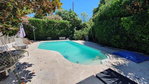 una piccola piscina in un cortile alberato di Bas de villa avec piscine a Marsiglia