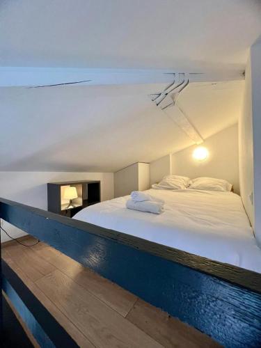 une chambre avec un grand lit blanc dans une pièce dans l'établissement Le Duplex Toulousain - Tram Métro - Centre ville, à Toulouse