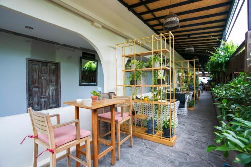 a table and chairs in a room with plants at JALMIN Hotel Samui in Chaweng