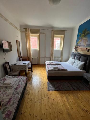 a room with two beds and two chairs in it at Sobe sa sopstvenim KUPATILOM Private rooms bathroom In CENTER in Novi Sad