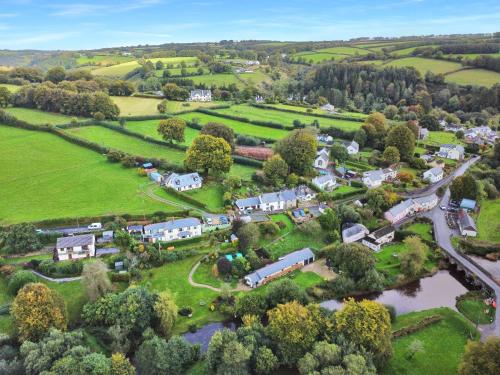 an aerial view of a village with houses and a river at Ormrods in Withypool