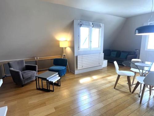 - un salon avec des chaises, une table et une fenêtre dans l'établissement Comfort & design 2 BR near Place des Vosges, à Paris
