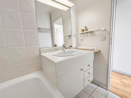 une salle de bain blanche avec un lavabo et un miroir dans l'établissement Pause Paisible à Rueil-Malmaison, à Rueil-Malmaison