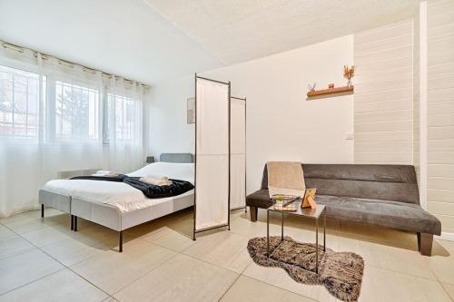 une chambre avec un lit, un miroir et un canapé dans l'établissement Welcome to Studio Bianca, au Blanc-Mesnil