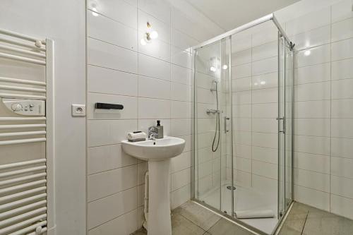 une salle de bain blanche avec un lavabo et une douche dans l'établissement Welcome to Studio Bianca, au Blanc-Mesnil
