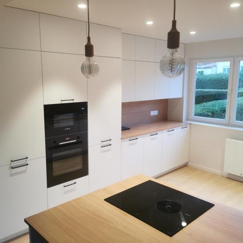 - une cuisine avec des placards blancs et une cuisinière noire dans l'établissement Villa WITSANDS, à Wissant