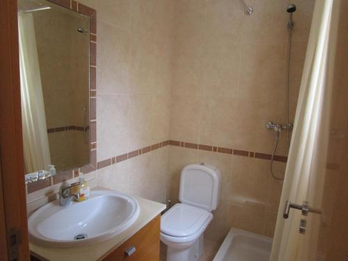 Un baño con un inodoro blanco y un lavabo. en Spacious Apartment in Old Ferragudo Village, en Ferragudo