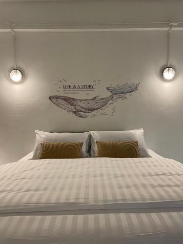 a bedroom with a bed with two lights on the wall at Rudica Seacret House in Rayong