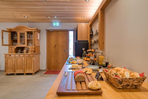 a long table with bread and other food on it at Naturhaus am Arlberg in Warth am Arlberg