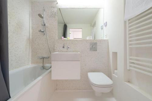 La salle de bains est pourvue de toilettes, d'un lavabo et d'une baignoire. dans l'établissement Ski in ski out with sought after location, aux Menuires