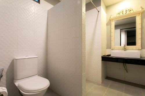 a bathroom with a toilet and a sink and a mirror at JALMIN Hotel Samui in Chaweng