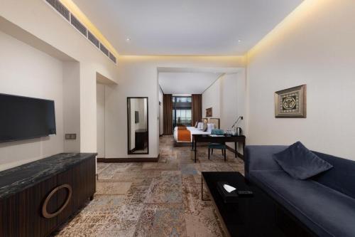 a living room with a couch and a flat screen tv at Warwick Al Khobar in Al Khobar