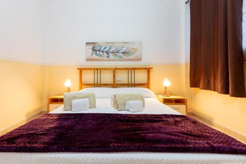 a bedroom with a large white bed with two pillows at 2A Apartamento Abrigos, Wifi y balcón in Los Abrigos