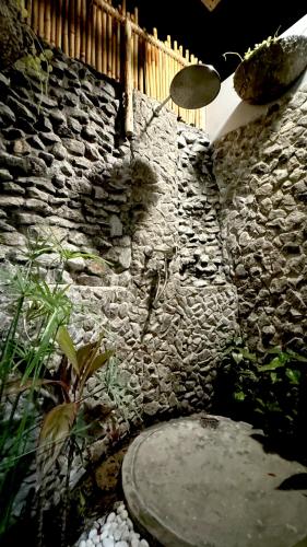 a stone wall with a stone walkway in front of a stone wall at Baa Sand Maldives in Kudarikilu