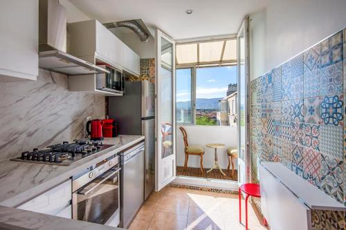 Il comprend une cuisine équipée d'une cuisinière. four supérieur à côté d'une fenêtre dans l'établissement Bright flat close to the beach, à Marseille