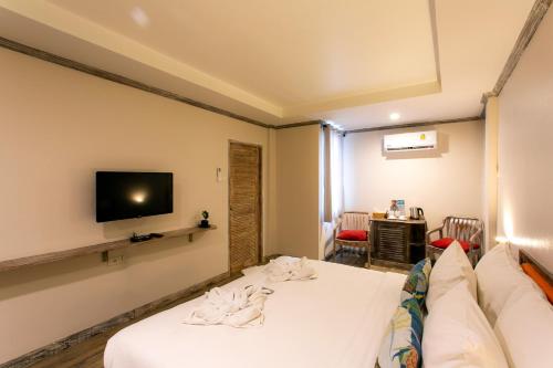 a hotel room with a bed and a tv at JALMIN Hotel Samui in Chaweng