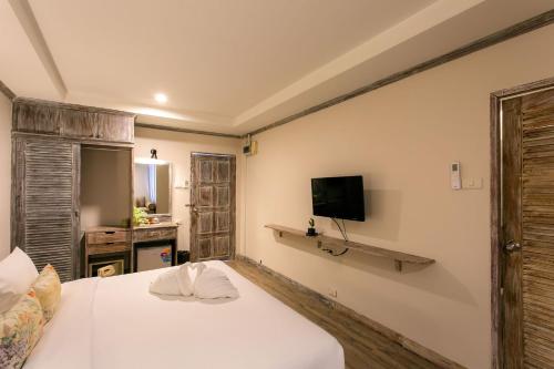 a bedroom with a white bed and a television at JALMIN Hotel Samui in Chaweng