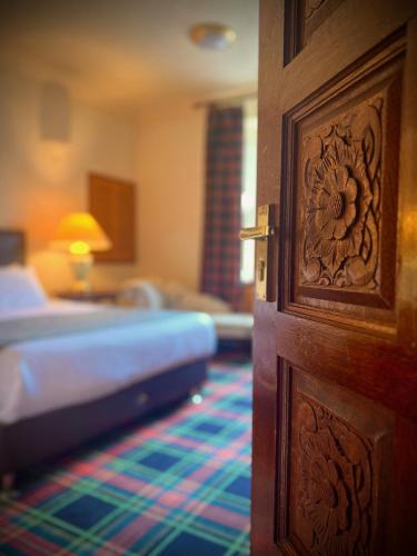 a door leading to a bedroom with a bed and a room at Loch Ness Lodge Hotel in Drumnadrochit