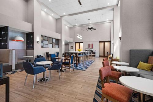 a restaurant with tables and chairs and a bar at Hampton Inn & Suites Pensacola I-10 N at University Town Plaza in Pensacola