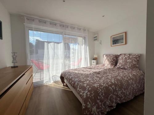 une chambre avec un lit et une grande fenêtre dans l'établissement La Villa Suzanne, à Saint-Germain-sur-Ay