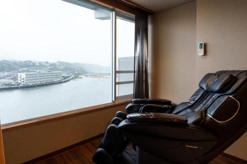 a room with two chairs in front of a large window at Hita Onsen Kizantei Hotel in Hita