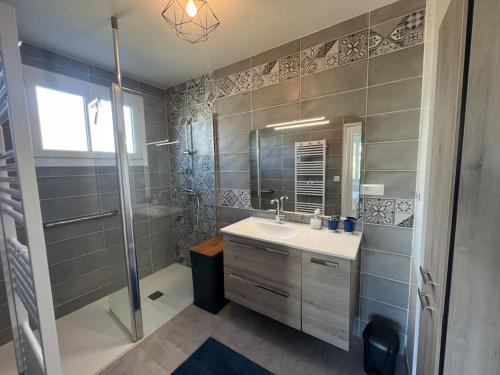 une salle de bain avec un lavabo et une douche dans l'établissement La Villa Suzanne, à Saint-Germain-sur-Ay
