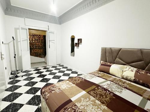 a bedroom with a bed and a checkered floor at Ftouh House Heart of Tangier in Tangier