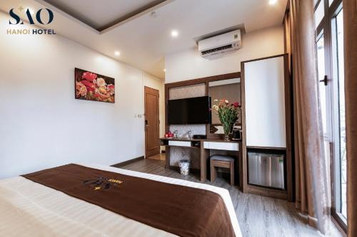 a hotel room with a large bed and a desk at Khách Sạn Sao in Hanoi