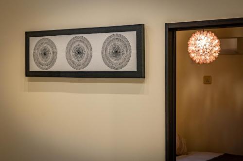 a picture hanging on a wall next to a mirror at 1688House美ら海 in Motobu