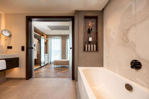 a bathroom with a tub and a sink at ATLANTIC Hotel Heidelberg in Heidelberg