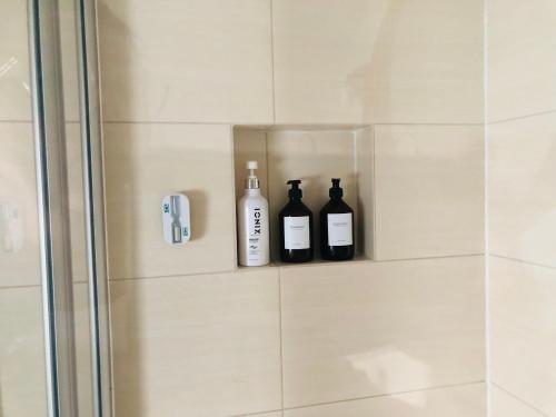 two bottles of wine are sitting on a shelf in a shower at Ferienwohnung Jung in Zülpich