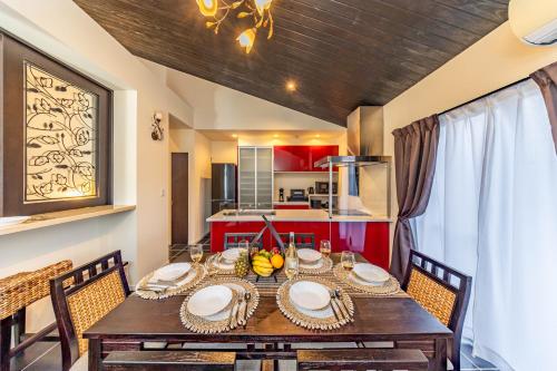 a dining room with a wooden table and chairs at 1688House美ら海 in Motobu