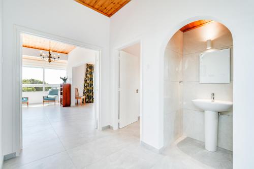 ein weißes Badezimmer mit Waschbecken und Spiegel in der Unterkunft Villa Bettina By Ezoria Villas in Coral Bay
